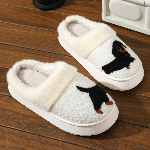 a pair of white slippers with a black dog on it